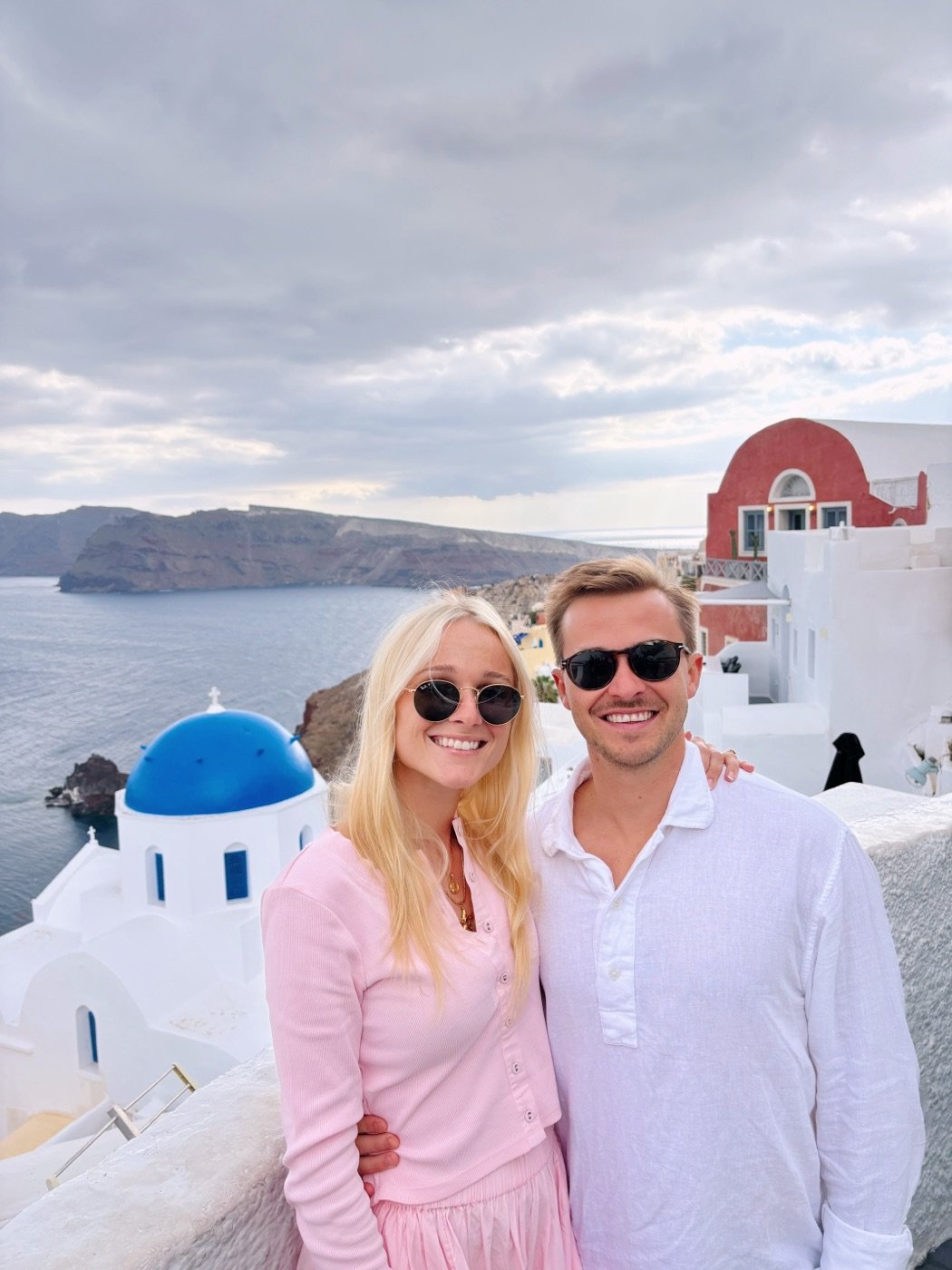Rick and his wife in front of a blue-domed church in Santorini