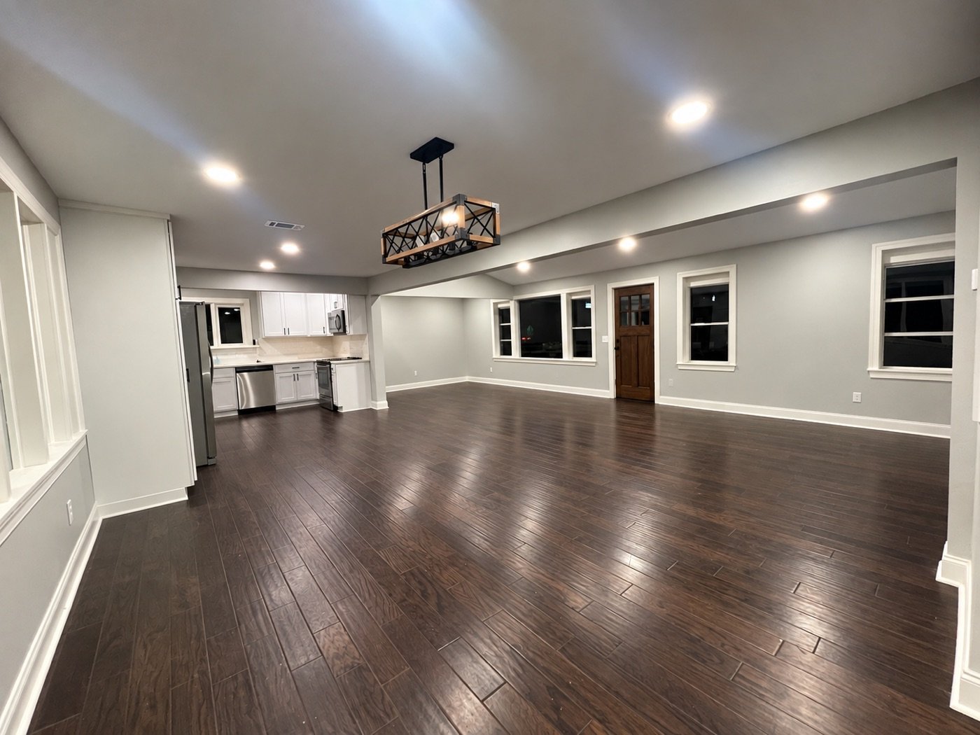 The finished open-plan interior with dark wood floors and a white kitchen
