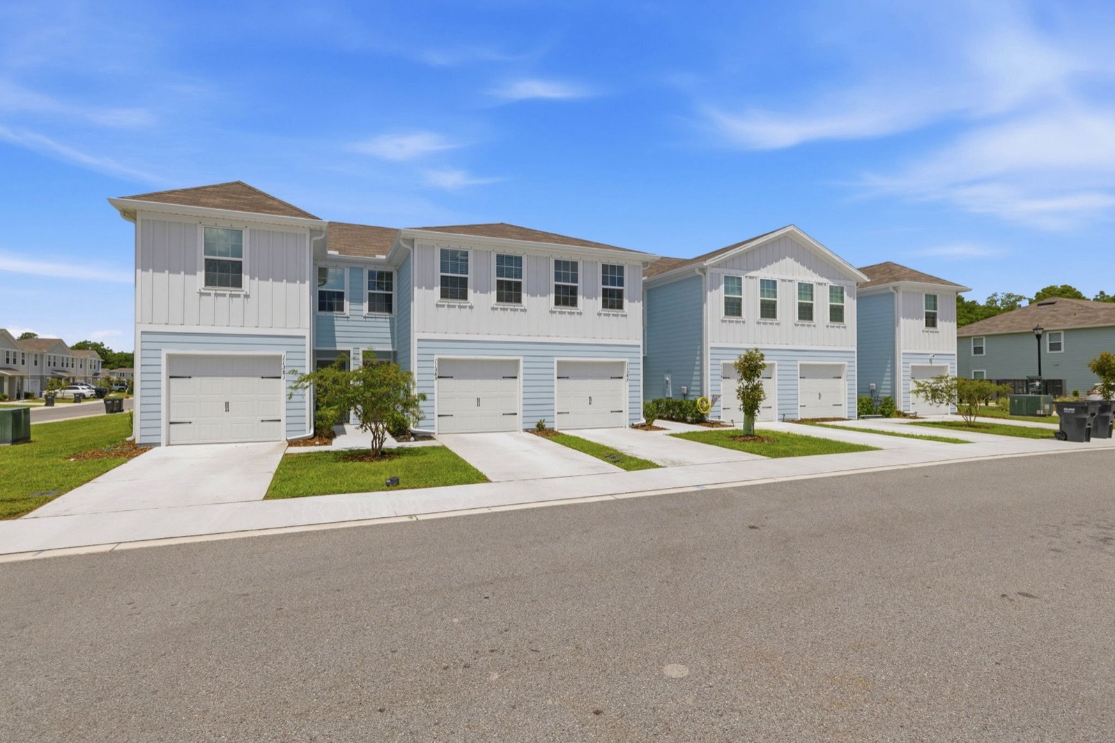 Row of blue and white townhomes under a bright sky